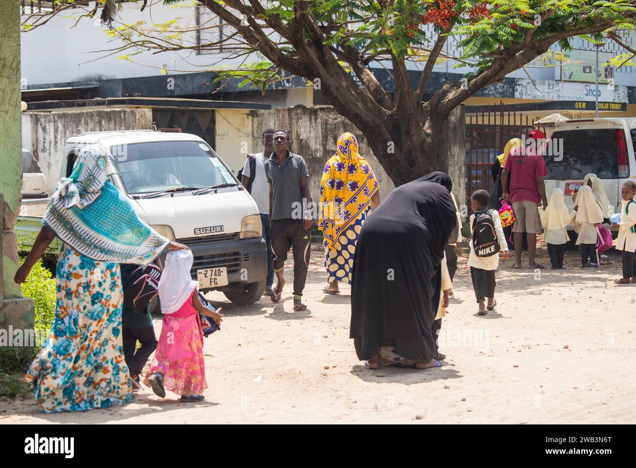 Zanzibar, Tanzanie - 01 mai,2022: Vue sur la rue de la vie quotidienne habituelle des gens de tous les âges se tenant le long de la route sur l'île de Zanzibar. Banque D'Images