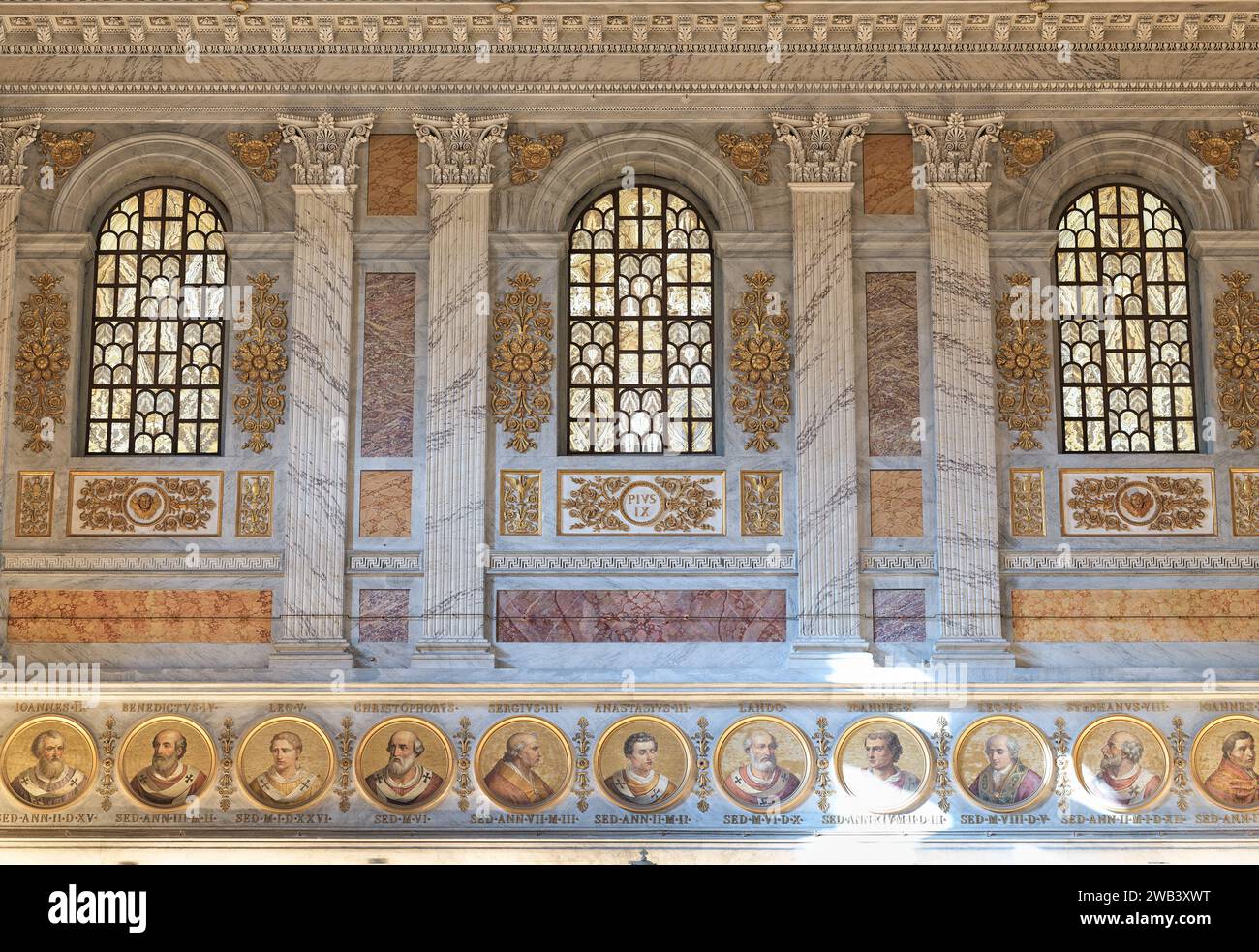 Trio de fenêtres, au-dessus de portraits en mosaïque de papes, à l'extrémité ouest de la basilique papale de Saint Paul hors les murs, Rome, Italie. Banque D'Images