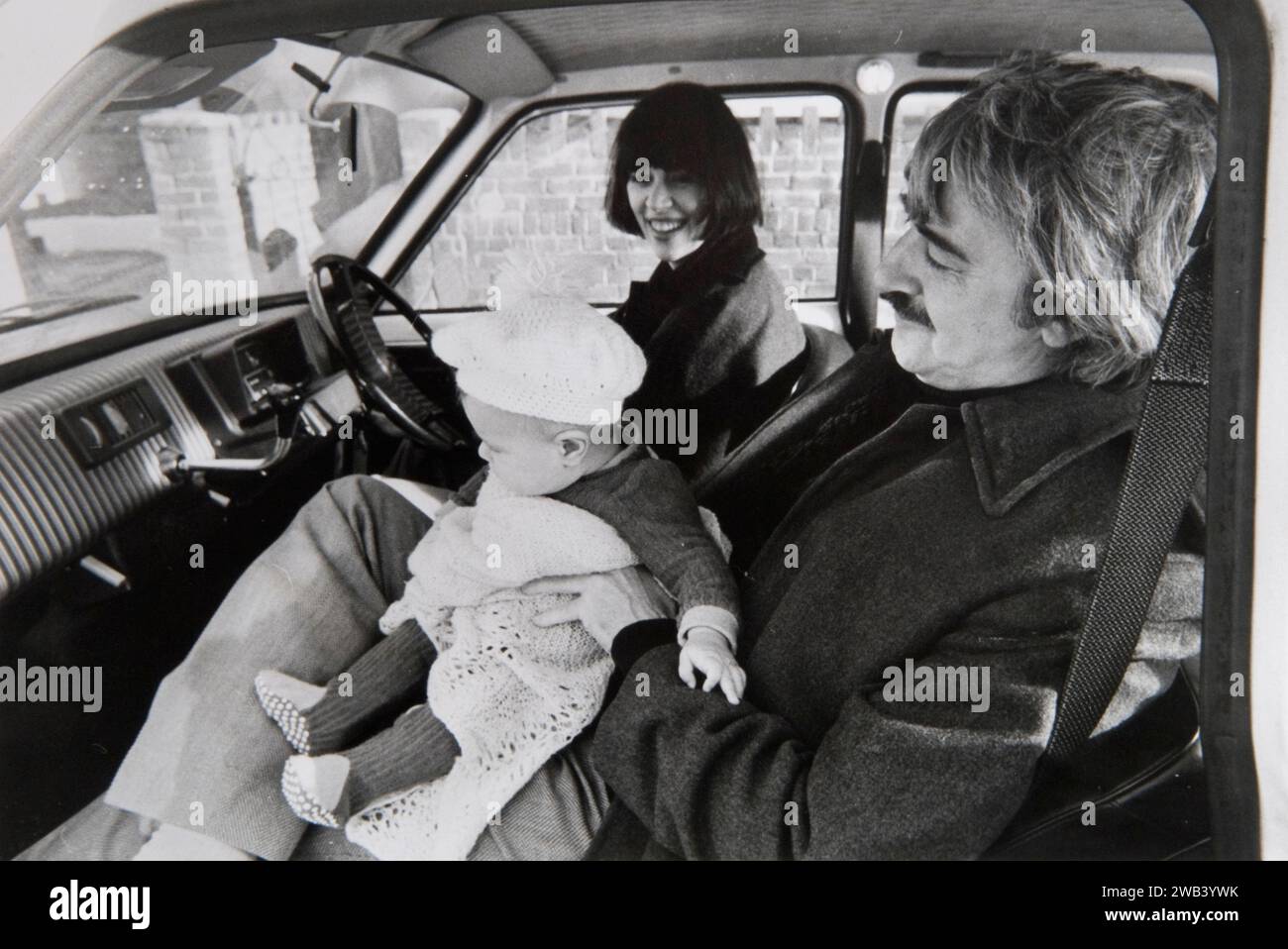 Kenneth MacMillan et Deborah MacMillan et le nouveau bébé Charlotte en voiture devant leur maison à Wandsworth. Kenneth MacMillan était un danseur et chorégraphe britannique qui était directeur artistique du Royal Ballet à Londres. En 1973, il travaille sur Manon, un ballet en trois actes en tant que directeur artistique. Deborah MacMillan was est une artiste qui a conçu des ballets pour la scène et la télévision. Wandsworth, Londres, Angleterre années 1970 Royaume-Uni HOMER SYKES Banque D'Images