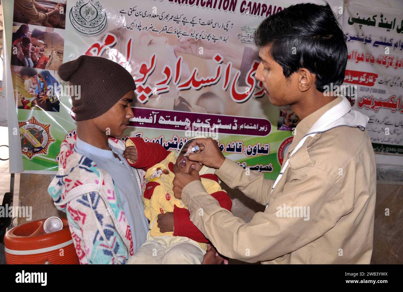 Un agent de santé administre des gouttes de vaccin contre la poliomyélite à un enfant lors de la campagne de vaccination contre la poliomyélite, à la gare de Hyderabad, le lundi 8 janvier 2024. Banque D'Images