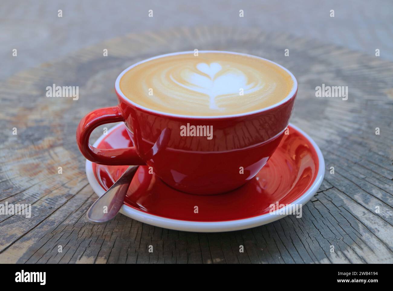 Tasse de café Cappuccino chaud sur une table de souche d'arbre Banque D'Images