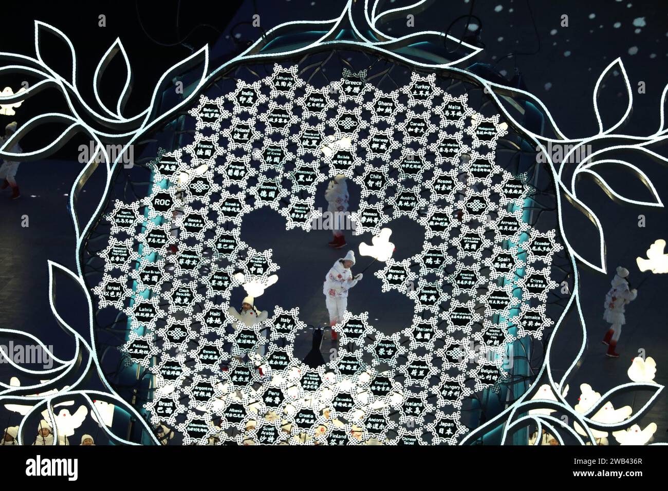 4 FÉV 2022 - Pékin, Chine : performance de flocons de neige où les enfants jouent heureux, tenant des lampes de colombe et des lanternes, laissant des traînées de neige scintillante Banque D'Images