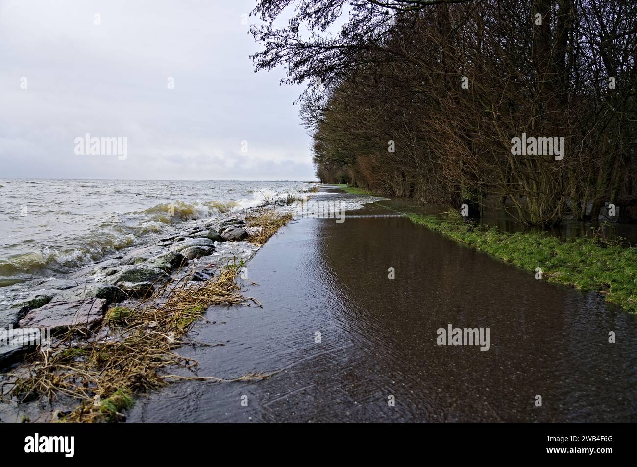 Niveau d'eau élevé en raison des fortes pluies et de la tempête, les vagues du lac Markermeer s'écrasent sur la digue de pierre et le sentier pédestre et inondent le parc hollandais Banque D'Images