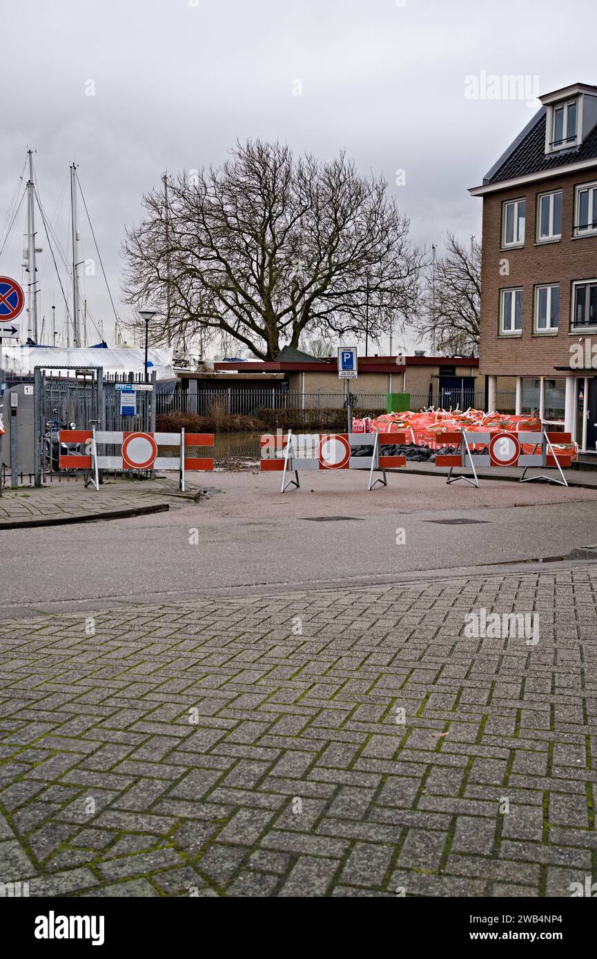 Route fermée en raison d'une rue inondée, crue causée par la tempête Henk. Sacs de sable et big bags placés par le gouvernement pour protéger les maisons, pays-Bas Banque D'Images