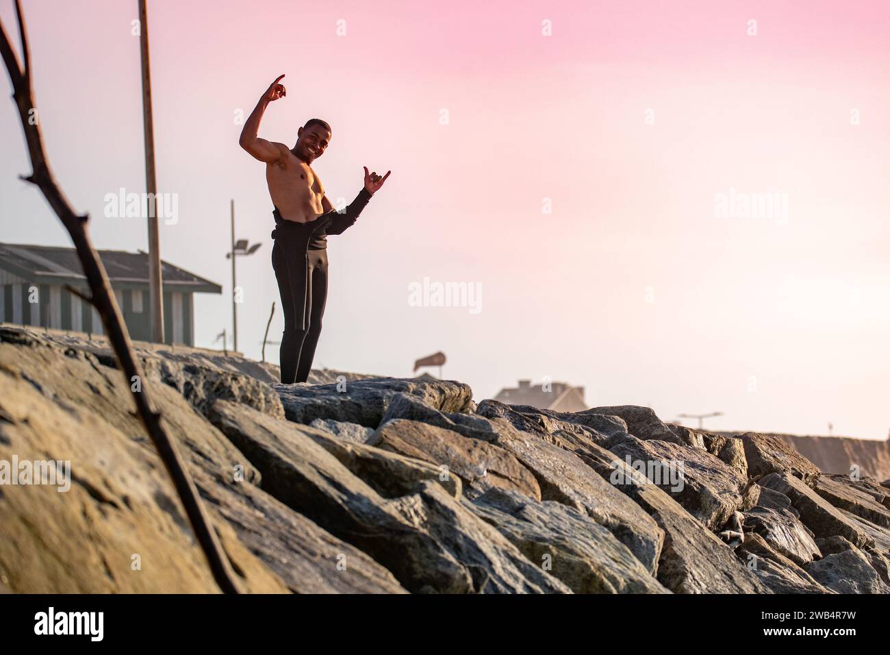 Le surfeur sourit et salue avec le panneau accroché Banque D'Images