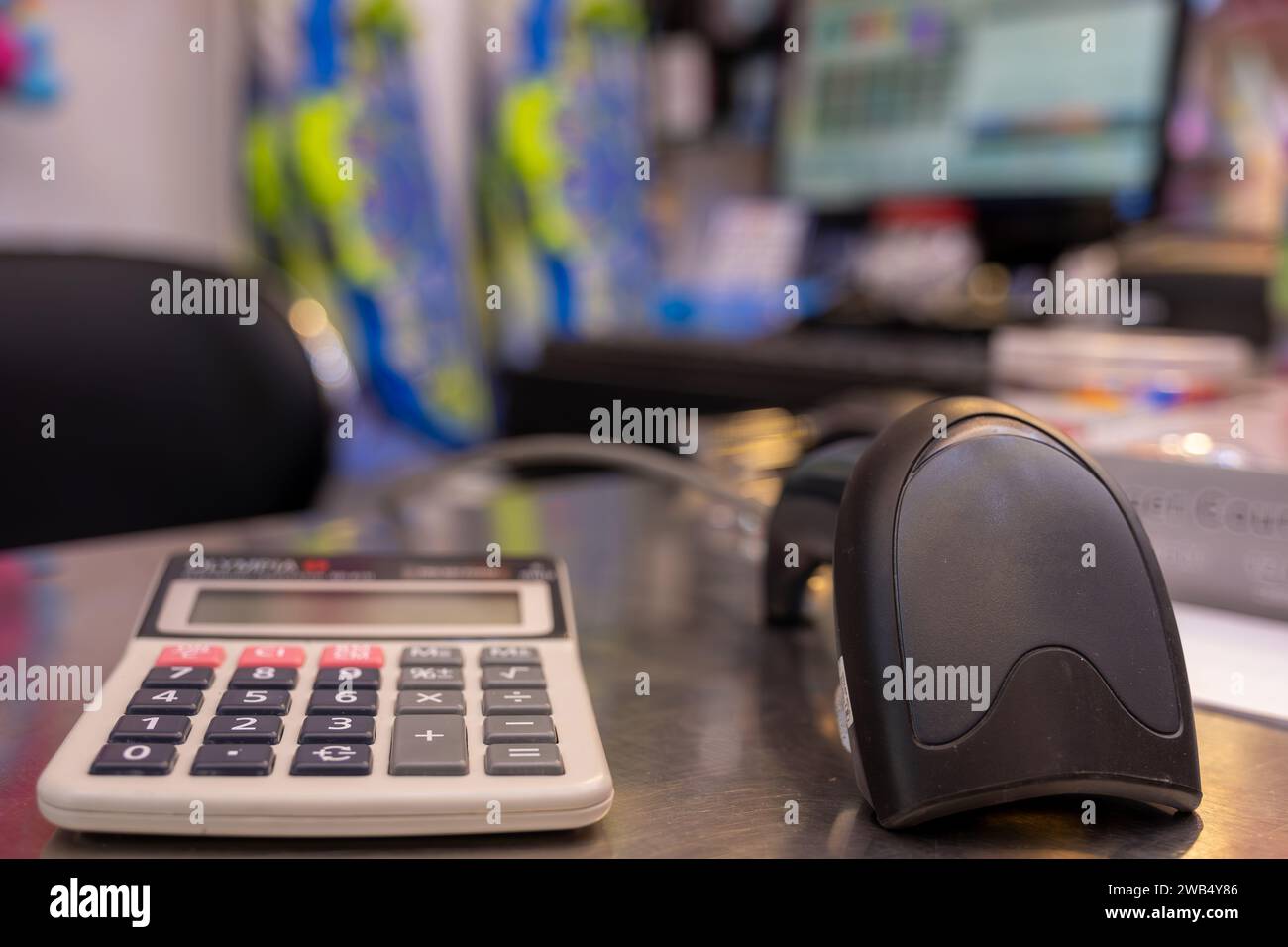 Scanner de code QR sur la table avec calculatrice avec écran cajou en arrière-plan dans Giftshop Banque D'Images