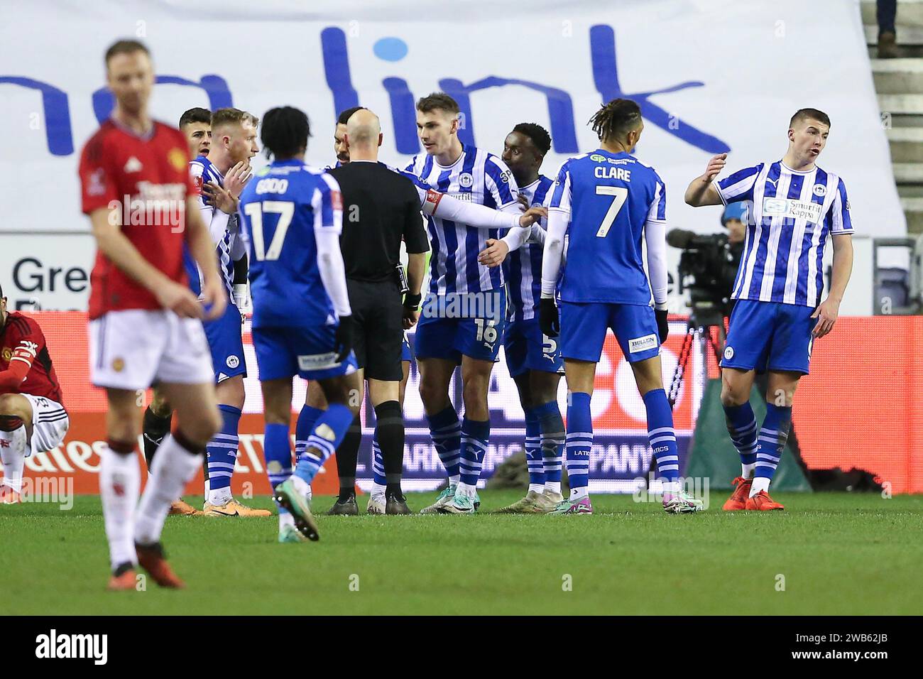 Wigan, Royaume-Uni. 08 janvier 2024. Les joueurs de Wigan entourent l'arbitre Anthony Taylor après qu'il ait attribué une pénalité à Manchester United. Emirates FA Cup, match de 3e tour, Wigan Athletic v Manchester Utd au DW Stadium à Wigan, Lancs, le lundi 8 janvier 2024. Cette image ne peut être utilisée qu'à des fins éditoriales. Usage éditorial uniquement, photo de Chris Stading/Andrew Orchard photographie sportive/Alamy Live News crédit : Andrew Orchard photographie sportive/Alamy Live News Banque D'Images