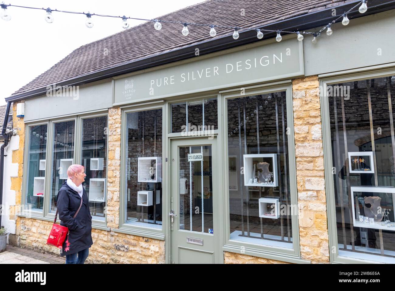 Modèle libéré femme shopping de vitrine pour des bijoux en argent dans un magasin à Stow sur les cotswolds Wold, shopping de vitrine car le magasin est fermé, Angleterre, 2023 Banque D'Images