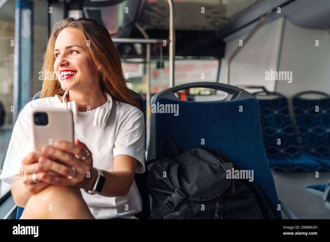 Jeune femme urbaine avec téléphone intelligent assis sur la navette. Transport de passagers et de la ville. Banque D'Images