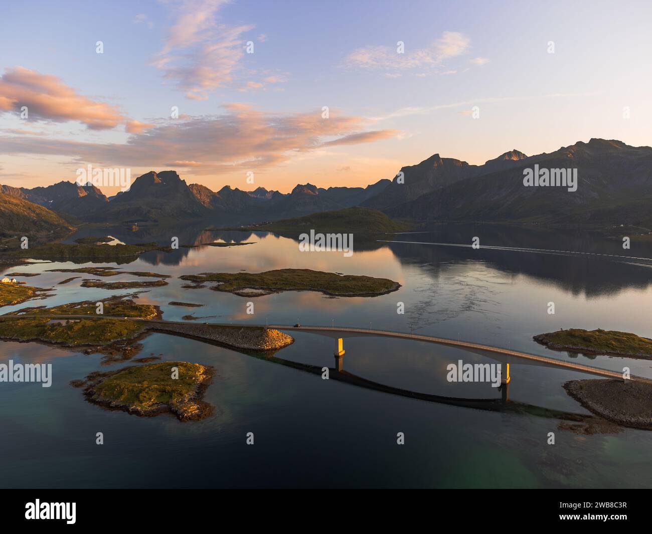 Vue aérienne des ponts Fredvang à Lofoten, Norvège avec une belle lumière de coucher de soleil sur la mer du fjord. Eaux calmes, reflets. Banque D'Images