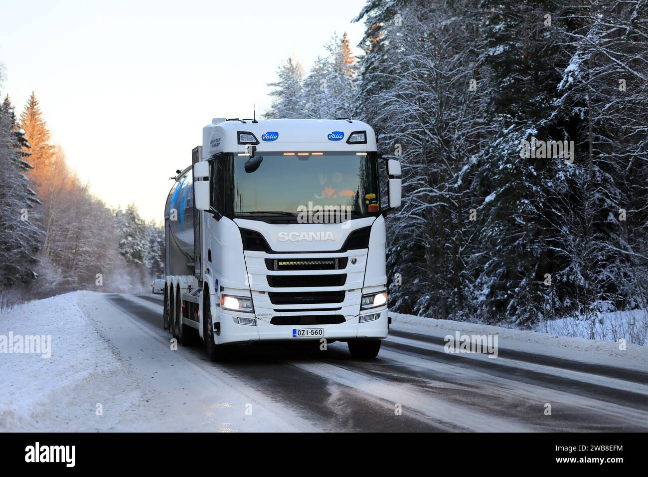 Le camion-citerne à lait blanc Scania 560R transporte le lait Valio le long de la route rurale un jour d'hiver. Salo, Finlande. 1 janvier 2024. Banque D'Images