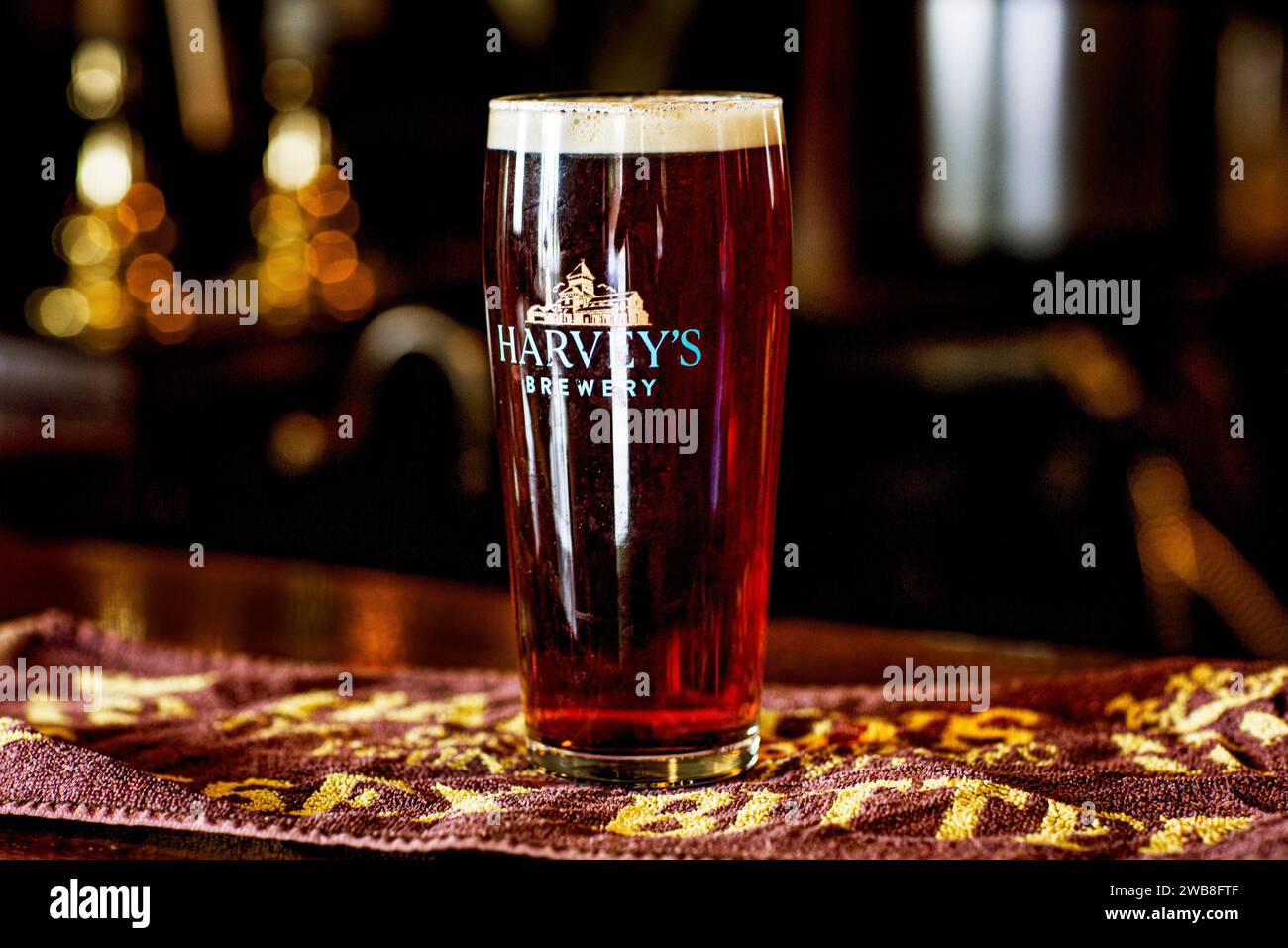 Une pinte fraîche de bière amère en fût sur une bière mate dans le pub. Banque D'Images