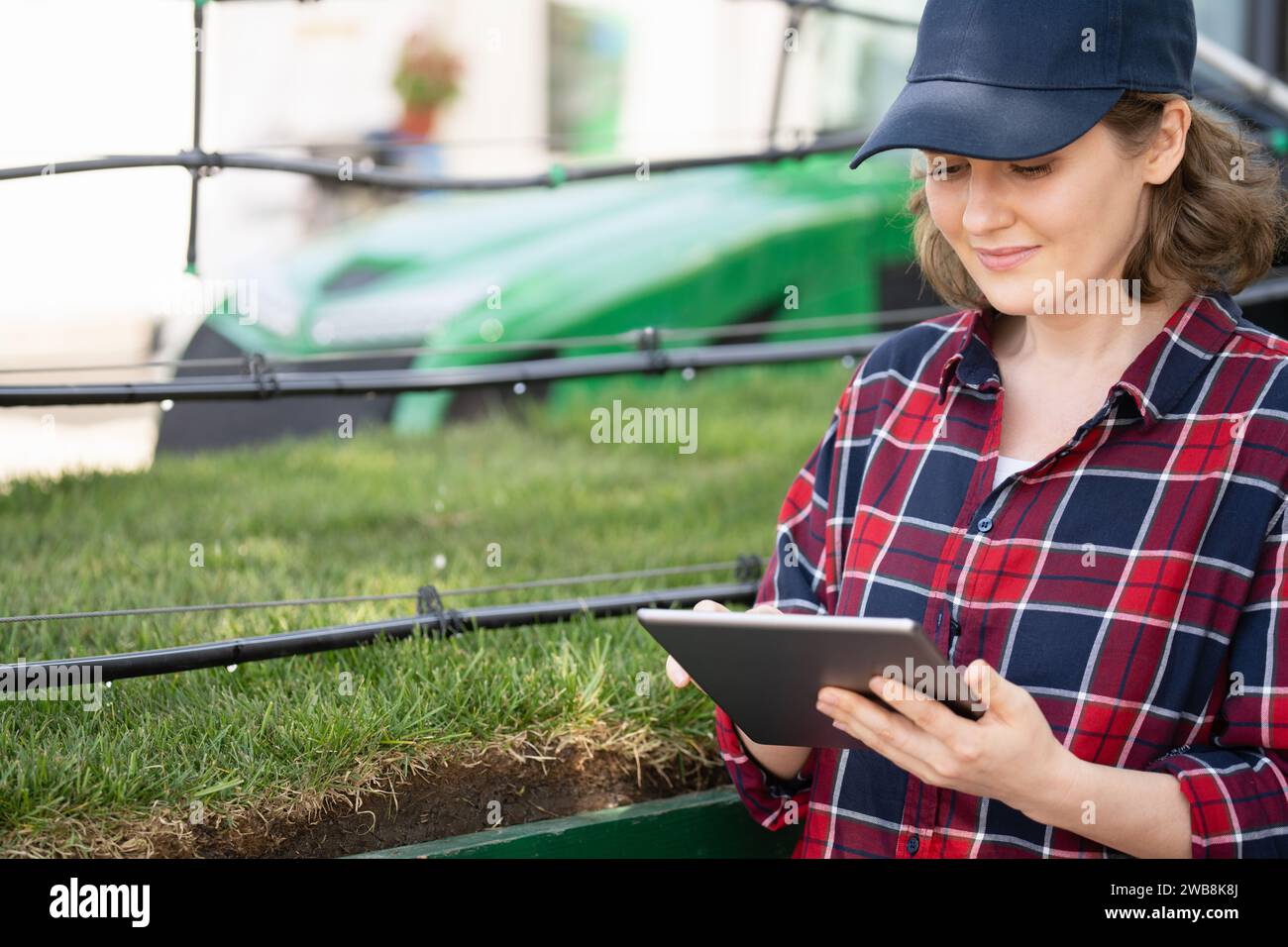 Farmer contrôle le système d'irrigation goutte-à-goutte avec la tablette numérique Banque D'Images