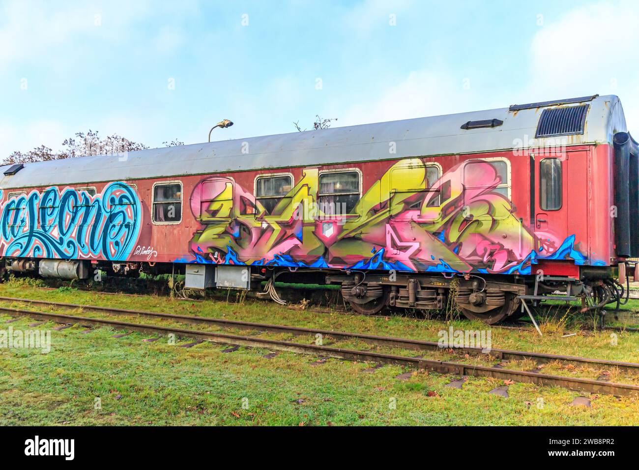 AS, Limbourg, Belgique. 17 décembre 2023. Voies ferrées désaffectées de la vieille gare avec très vieille voiture de tourisme en feuille rouge avec portes et fenêtres peintes avec Banque D'Images