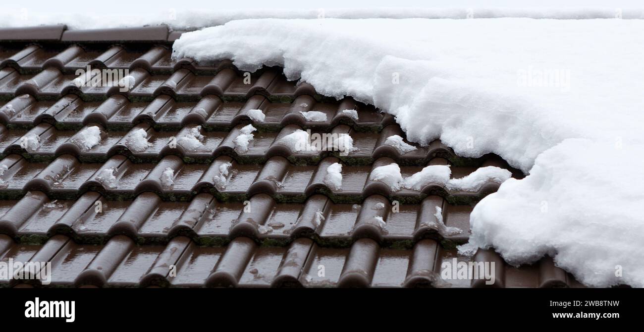 Le toit est carrelé, la neige fondante. Scène printanière. Paysage printanier. Banque D'Images