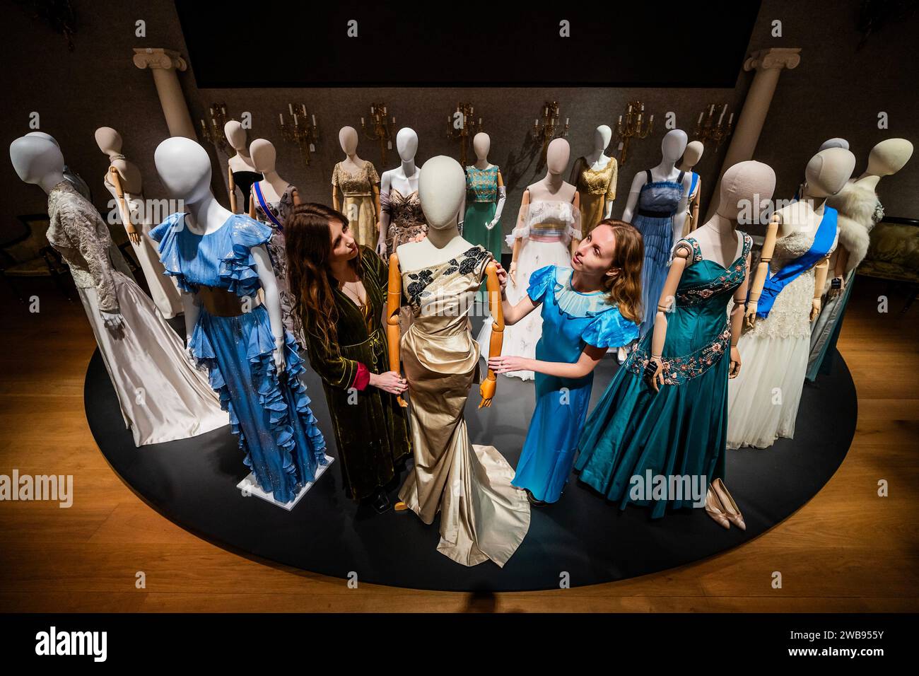 Londres, Royaume-Uni. 9 Jan 2024. Quelques-unes des nombreuses robes, y compris une robe de bal sarcelle pleine longueur, présentée dans l'affiche promotionnelle ( © Netflix 2020, Inc.) portée par ClareFoy dans la saison 2, épisode 1 et épisode 4. Estimation : £3 000-£5 000 et un porté par Lia Williams (en tant que Wallis Simpson) : une colonne de bal pleine longueur dans la saison 1, épisode 5, 'Smoke and Mirrors', £1 500 - £2 000 - Un aperçu de la Crown Auction à Bonhams New Bond Street, Londres. Plus de 450 costumes, décors et accessoires de la série primée The Crown, une émission Netflix. Crédit : Guy Bell/Alamy Live News Banque D'Images