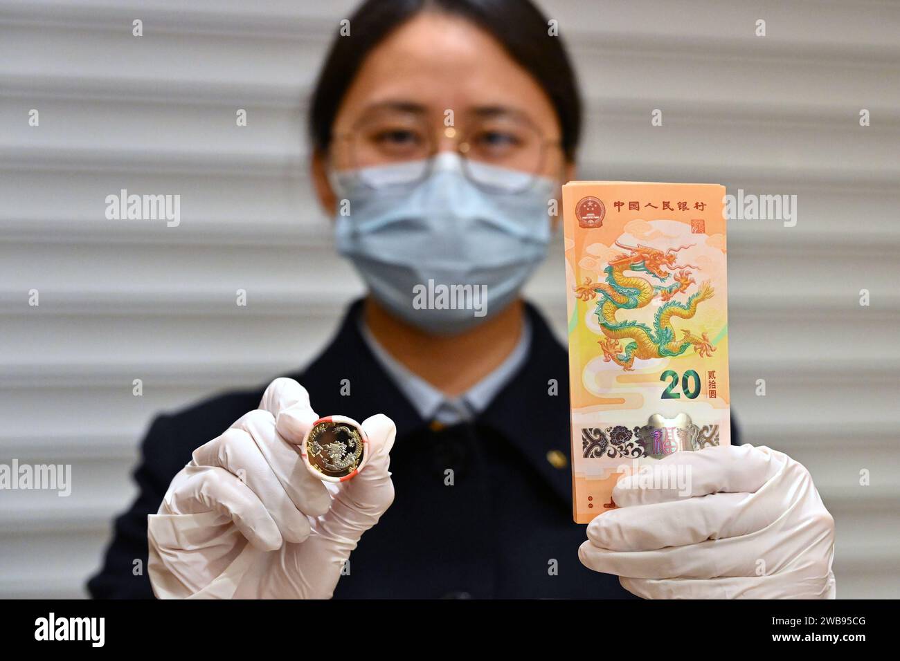 Pékin, Chine. 9 janvier 2024. Un membre du personnel montre des pièces commémoratives et des