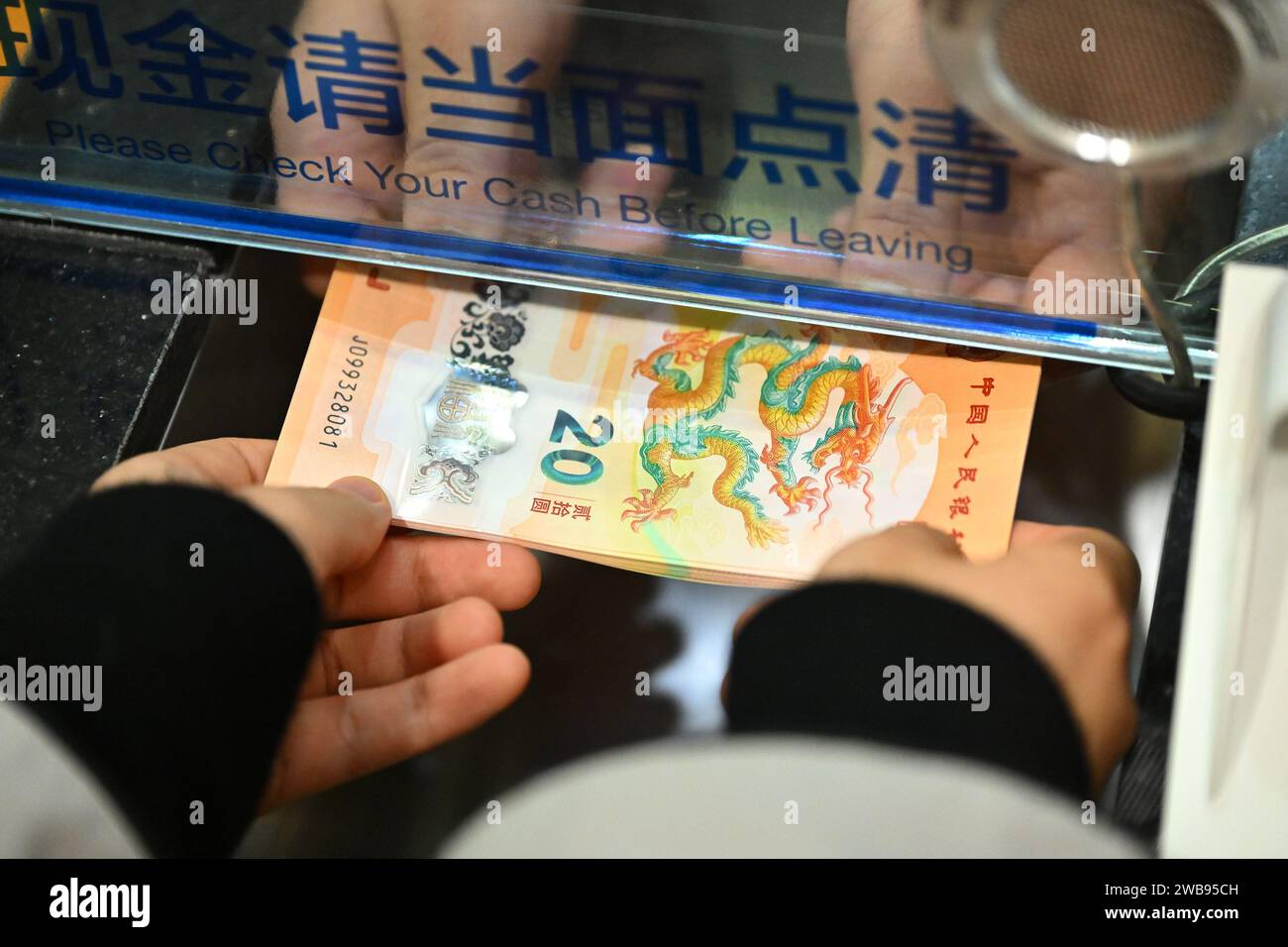 Pékin, Chine. 9 janvier 2024. Un citoyen échange des billets de banque commémoratifs pour