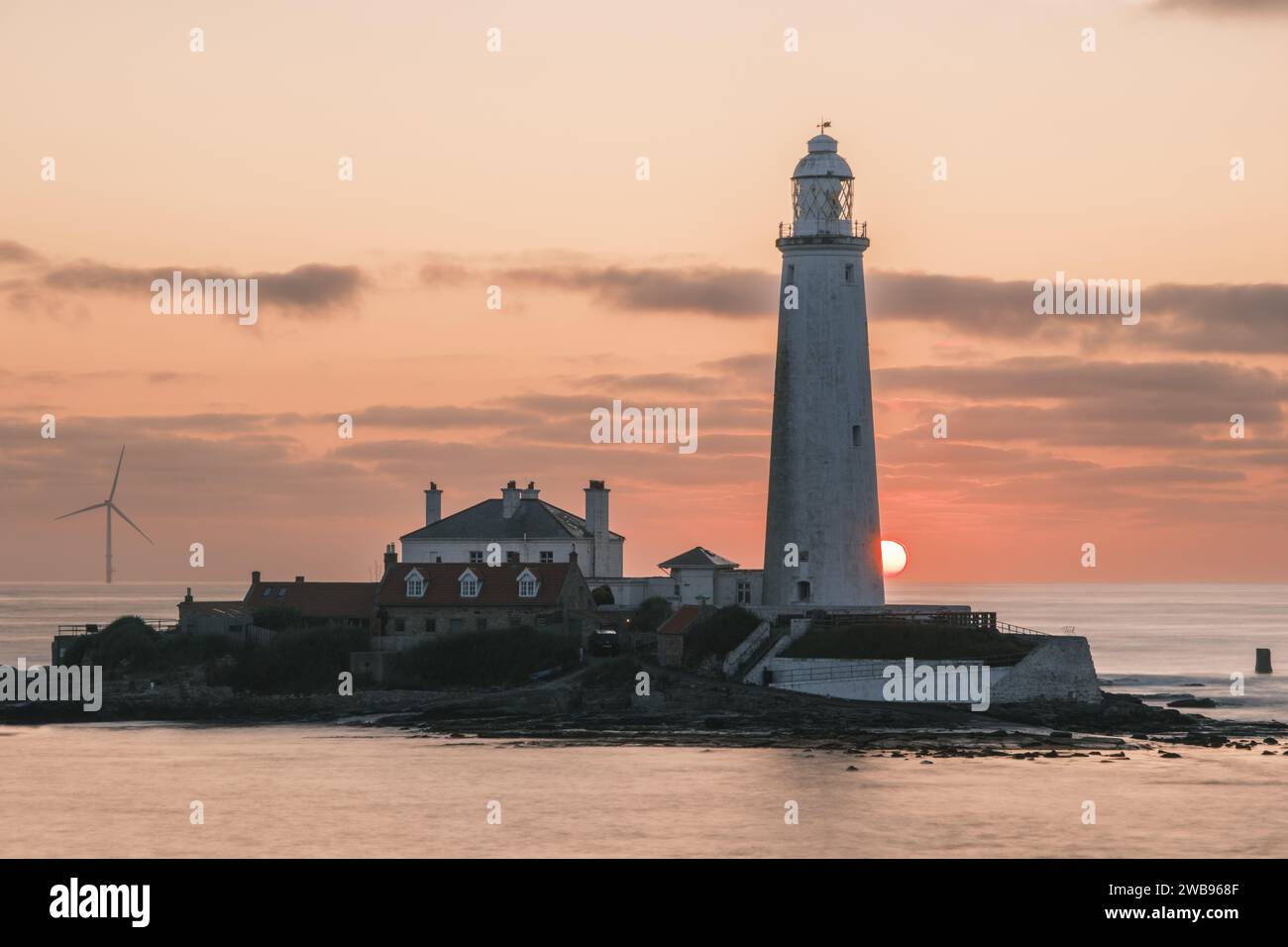 Le soleil se lève derrière le phare de St Mary's à Whitely Bay par un magnifique matin d'été. Banque D'Images
