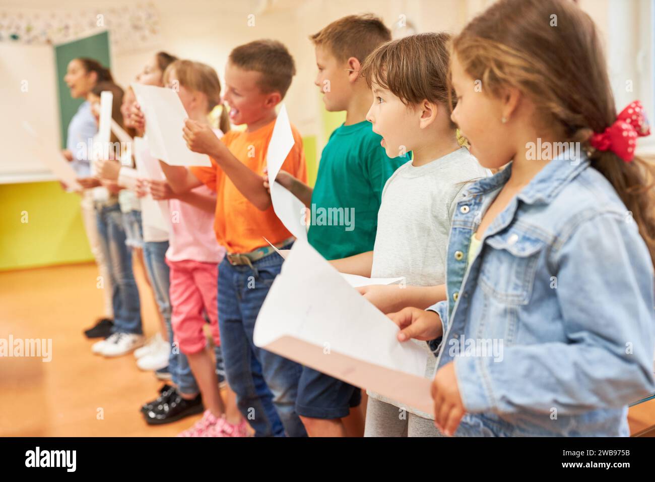 Élèves de l'école primaire chantant chœur pendant l'activité en classe Banque D'Images Élèves de l'école primaire chantant chœur pendant l'activité en classe Banque D'Images