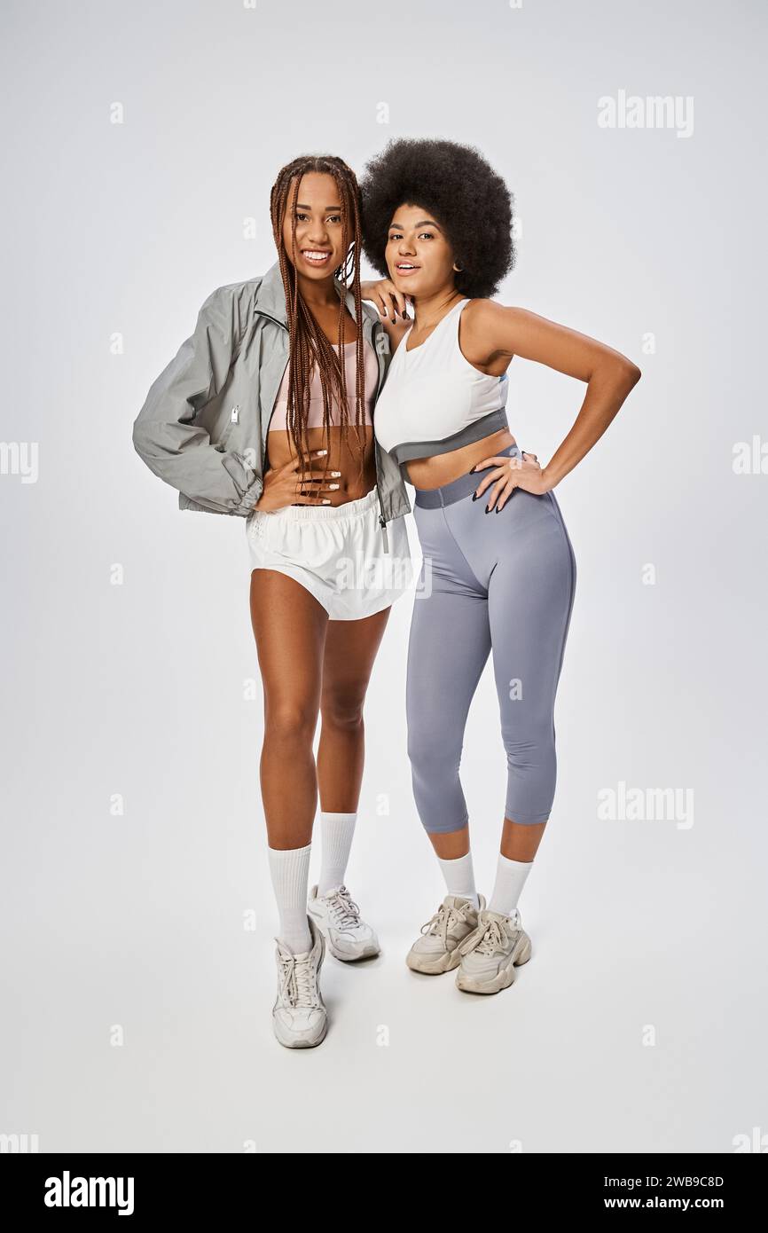 Longueur complète de femmes afro-américaines en forme posant ensemble sur fond gris, concept Juneteenth Banque D'Images