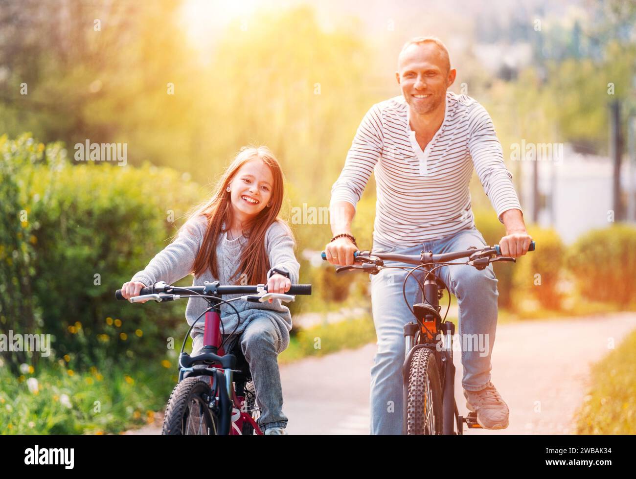 Portraits souriant père avec fille pendant l'été randonnée à vélo en plein air. Ils apprécient la convivialité dans le parc de la ville d'été. Bonne parentalité et chi Banque D'Images