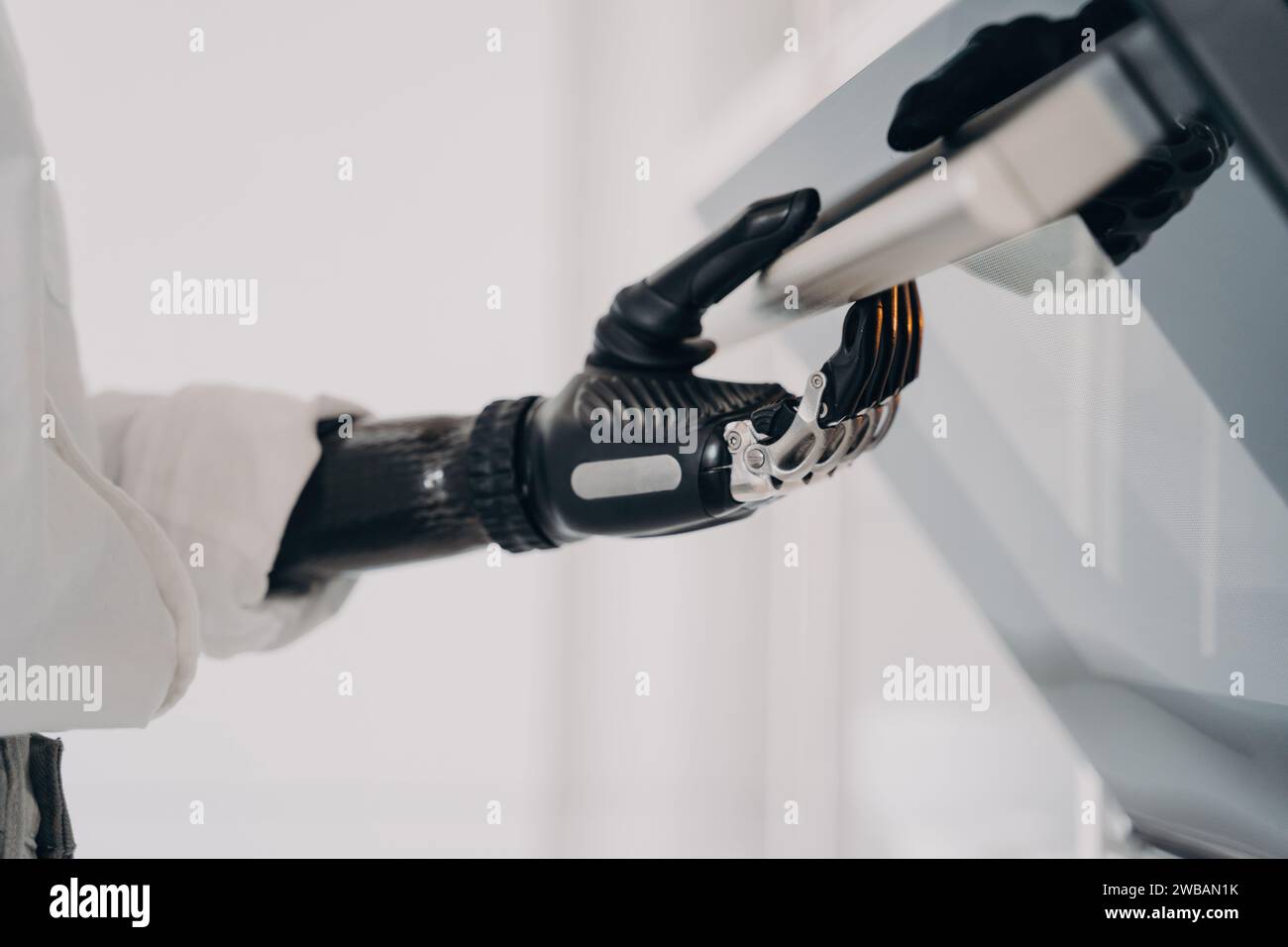 Précision et technologie convergent alors qu’une main bionique actionne un panneau de commande, symbolisant la nouvelle ère de l’intégration homme-machine Banque D'Images