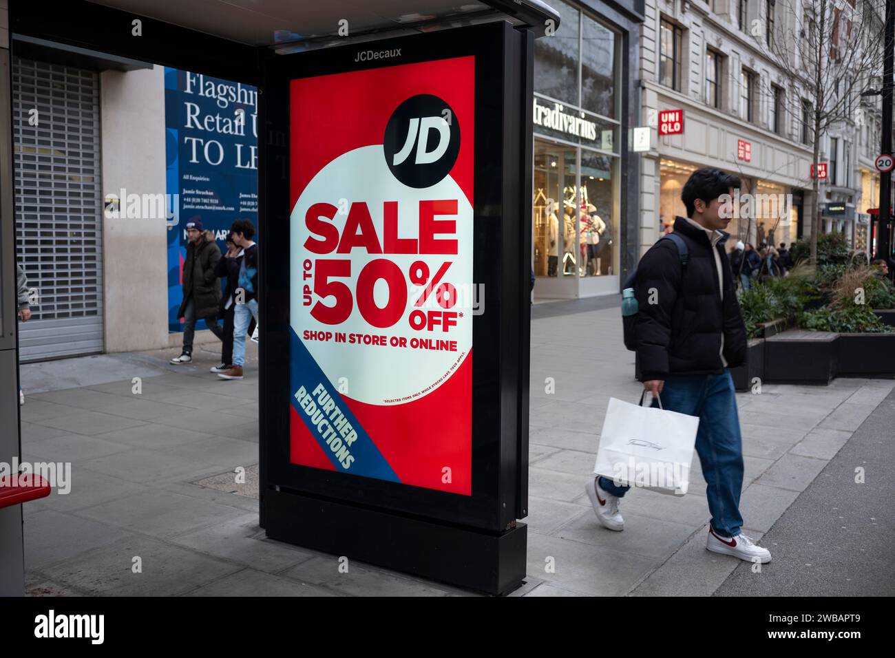 Panneau lumineux DE VENTE numérique 50% à un abri d'arrêt de bus le long d'Oxford Street dans le centre de Londres, Angleterre, Royaume-Uni Banque D'Images