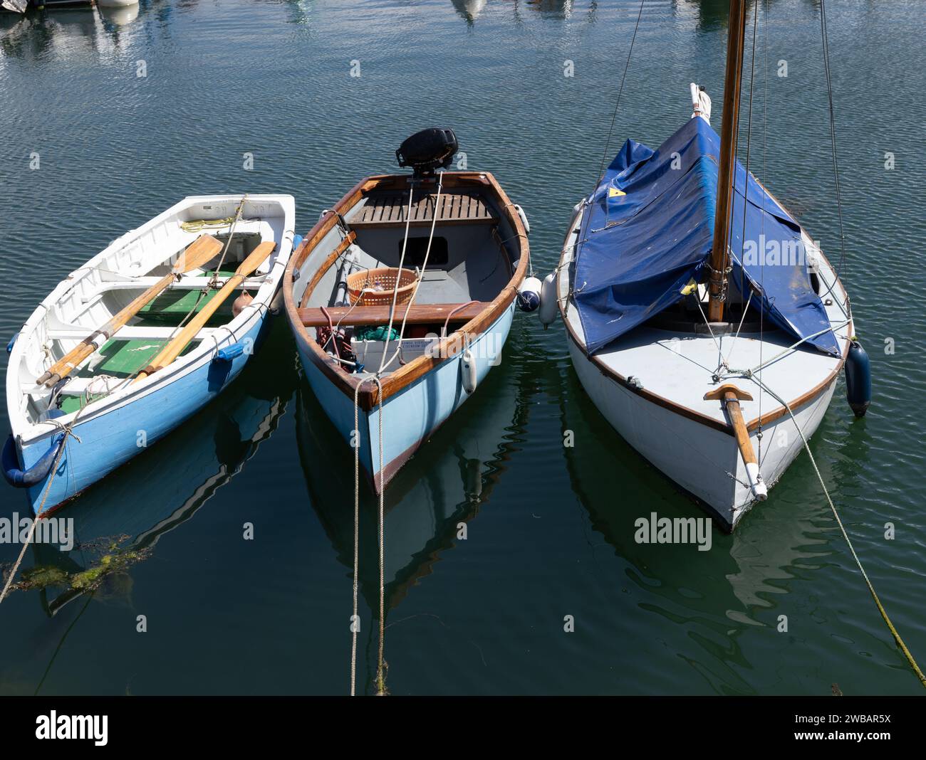 Trois bateaux traditionnels à rames et à voiles amarrés dans une rangée Banque D'Images