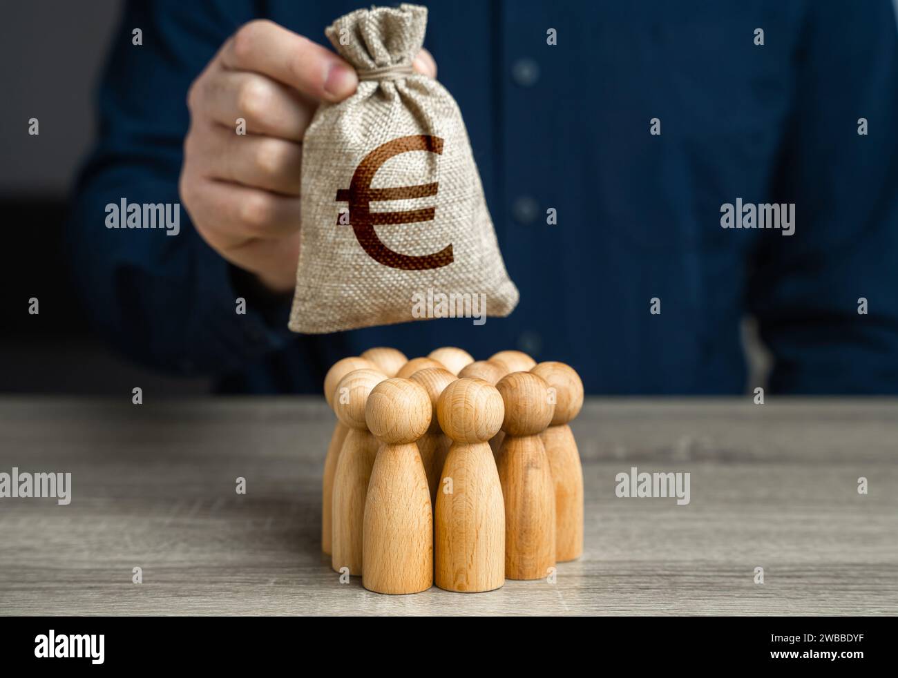 Un homme tient un sac d'argent en euros au-dessus d'un groupe de figurines de personnes. Génération de fonds à partir de la coopération. Organisation du budget communautaire. Paymen Banque D'Images