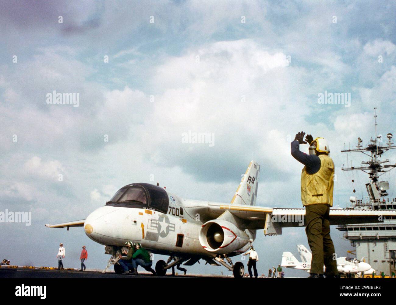 Un directeur d'avion signale des instructions au pilote d'un S-3a Viking alors que l'avion est positionné sur une catapulte pendant les opérations de vol à bord du porte-avions nucléaire USS THEODORE ROOSEVELT (CVN-71) 1987 Banque D'Images