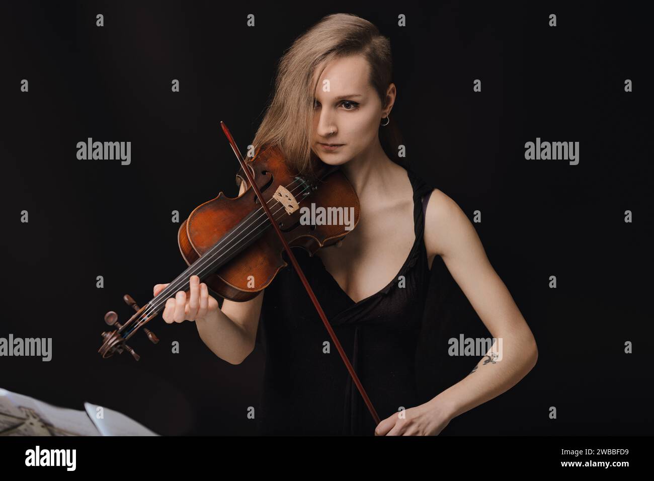 l'expression focalisée de la violoniste transmet la profondeur de sa performance, soulignant le lien intime avec son instrument Banque D'Images