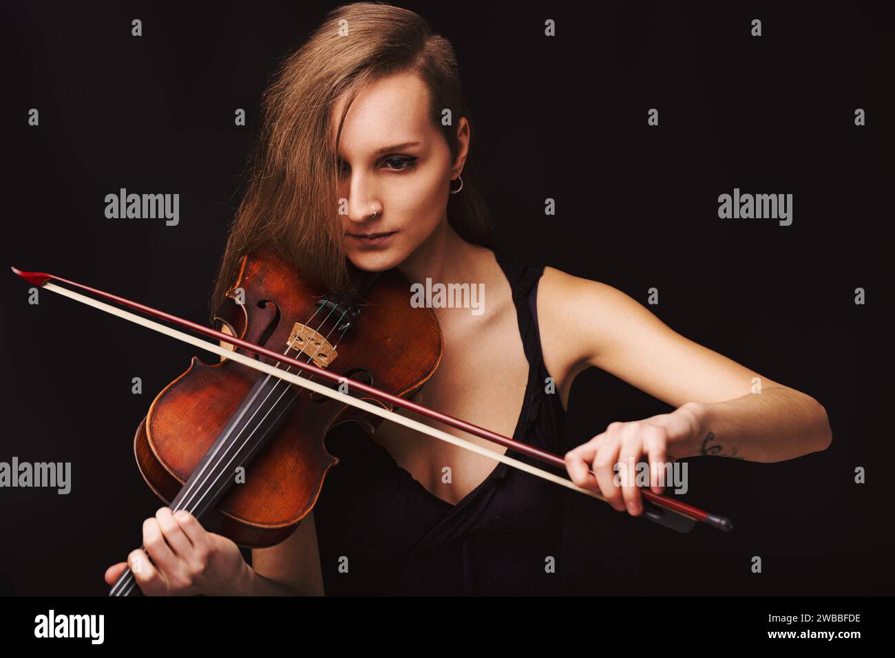 Gros plan sur une musicienne dévouée imprégnée de son art, le violon devient une extension de son esprit créatif Banque D'Images