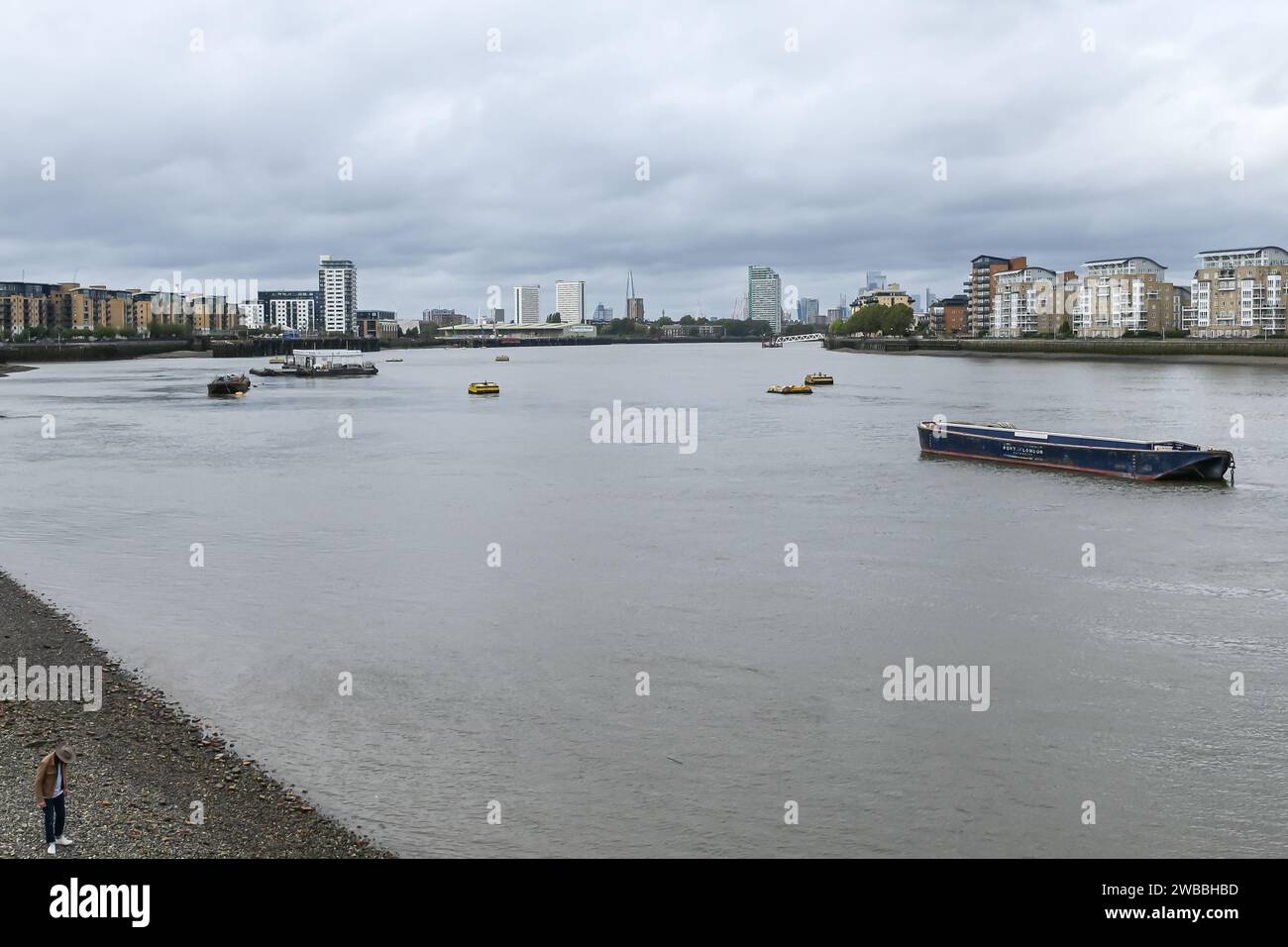 Homme marcher sur le rivage exposé sur la Tamise à basse eau à Greenwich par Cutty Sark Banque D'Images