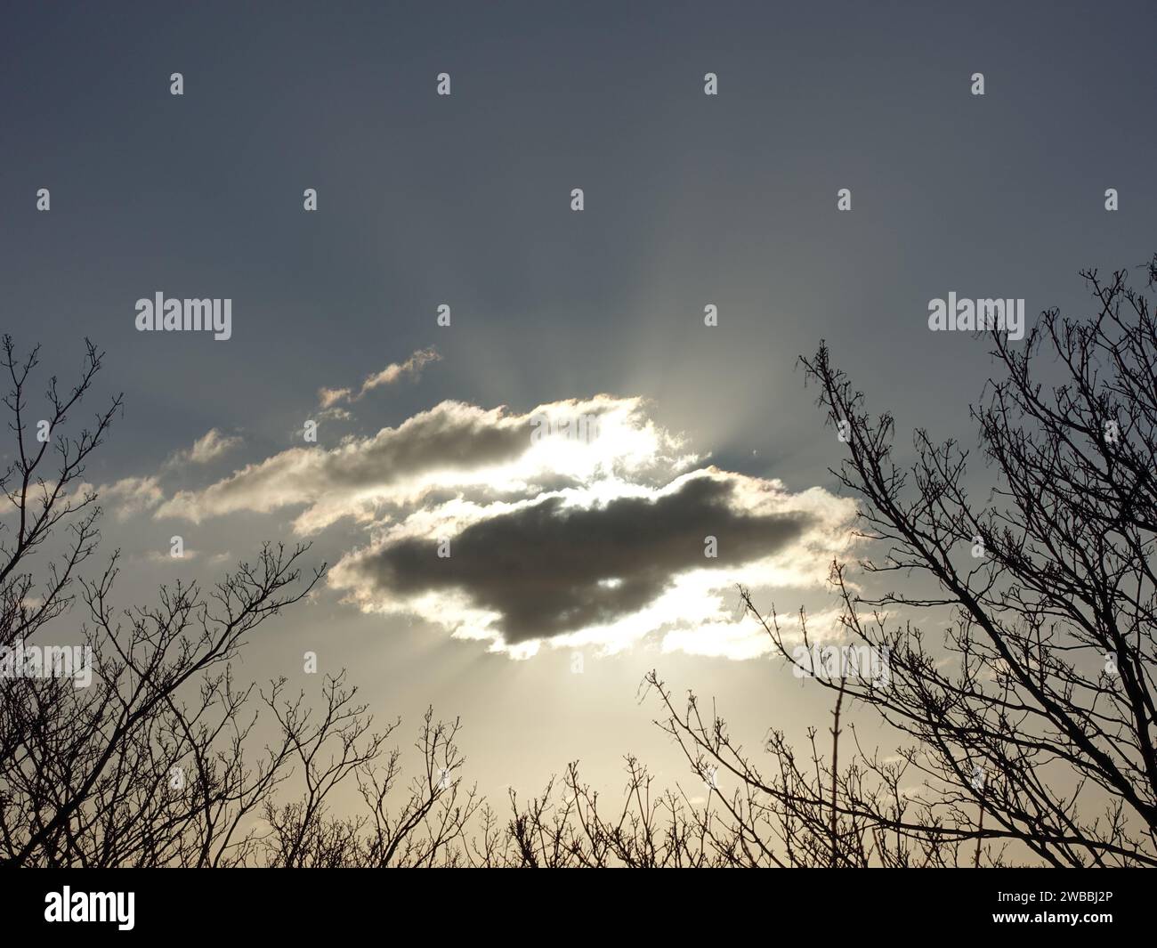 Soleil derrière les nuages Banque D'Images