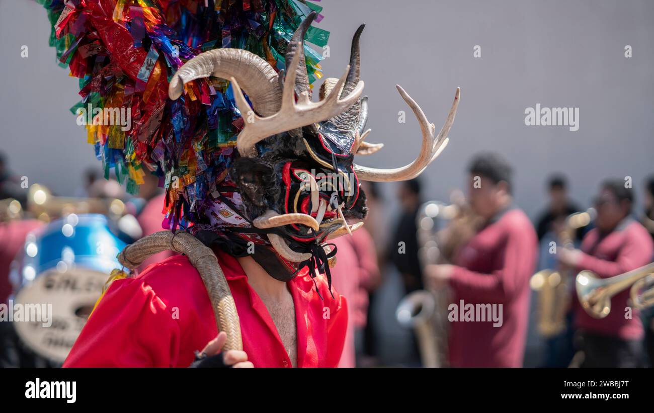 Pillaro, Tungurahua / Équateur - janvier 5 2024 : Homme habillé en diable noir et rouge, vu de profil, défilant dans la Diablada Pillarena dans la ville Banque D'Images
