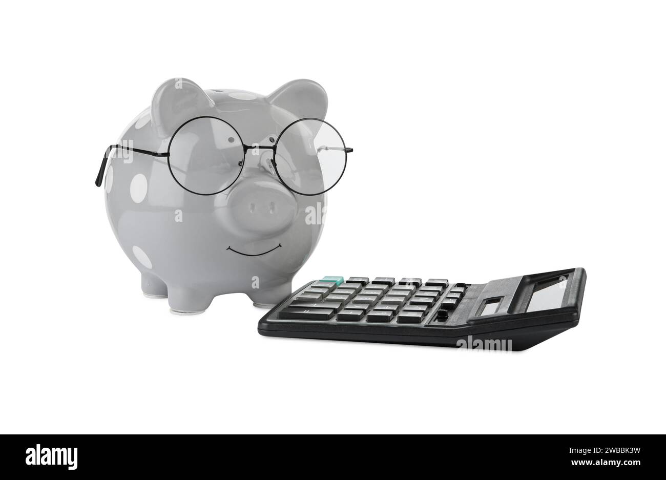 Calculatrice et tirelire grise dans des verres isolés sur blanc Banque D'Images