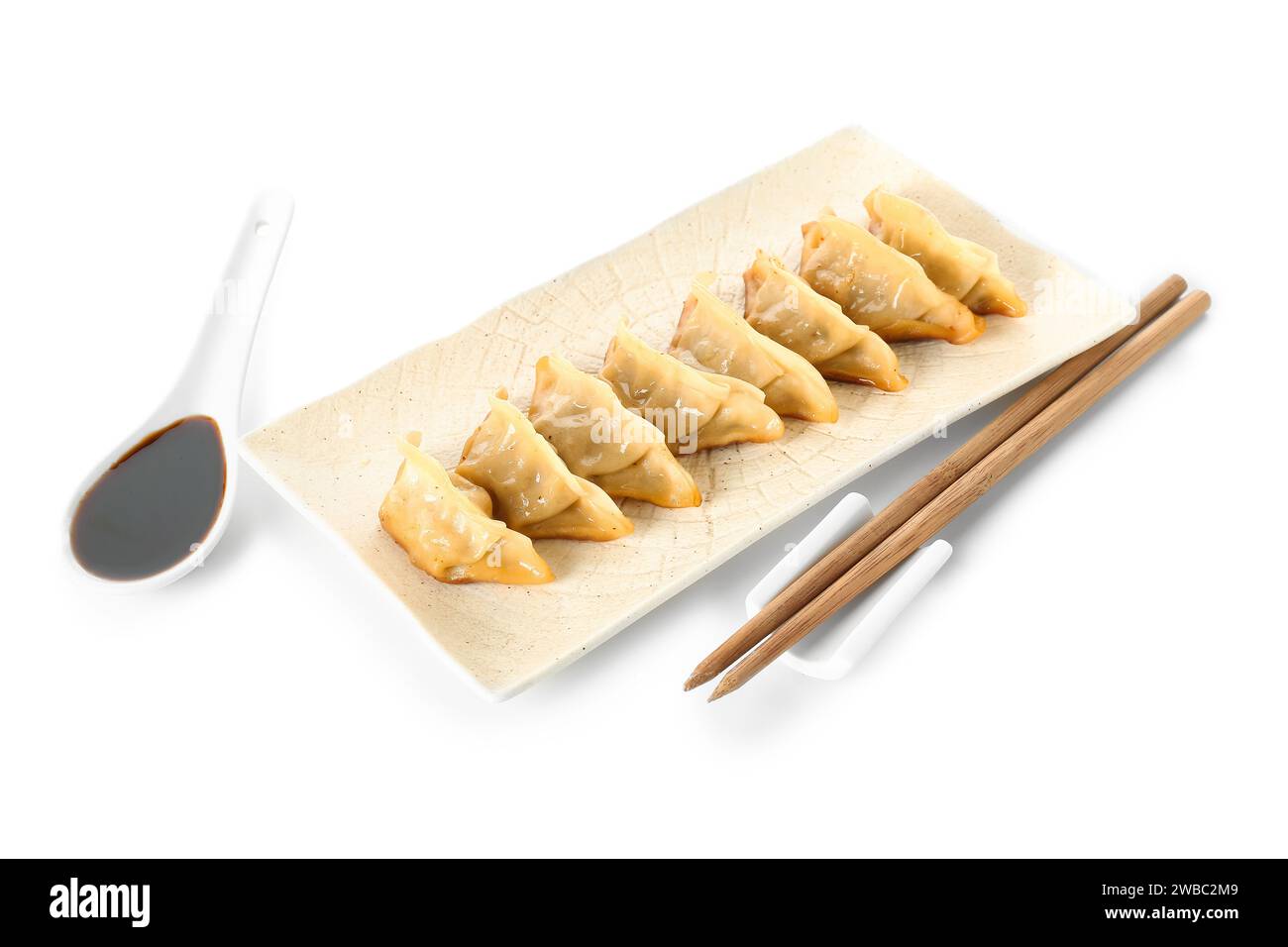 Assiette avec de savoureux jiaozi chinois et sauce sur fond blanc Banque D'Images
