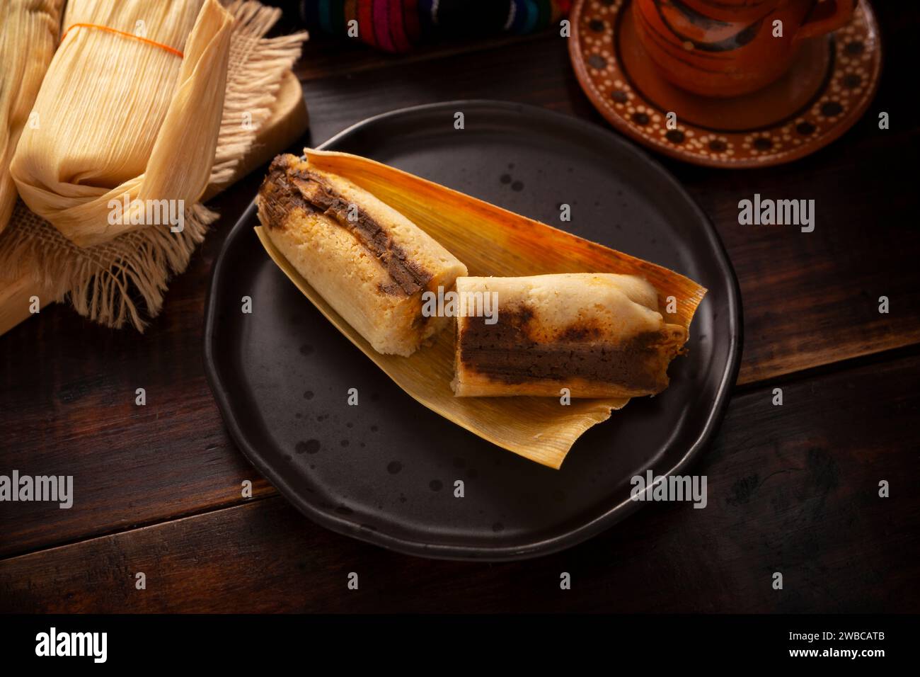 Tamales. Plat hispanique typique du Mexique et de certains pays d'Amérique latine. Pâte de maïs enveloppée dans des feuilles de maïs. Les tamales sont cuits à la vapeur. Banque D'Images