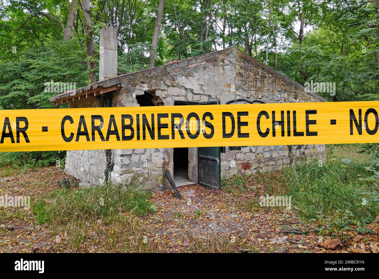 Cabane abandonnée dans les bois avec une bande de police avec écrit dedans en espagnol 'Carabineros de Chile - No pasar'. Banque D'Images