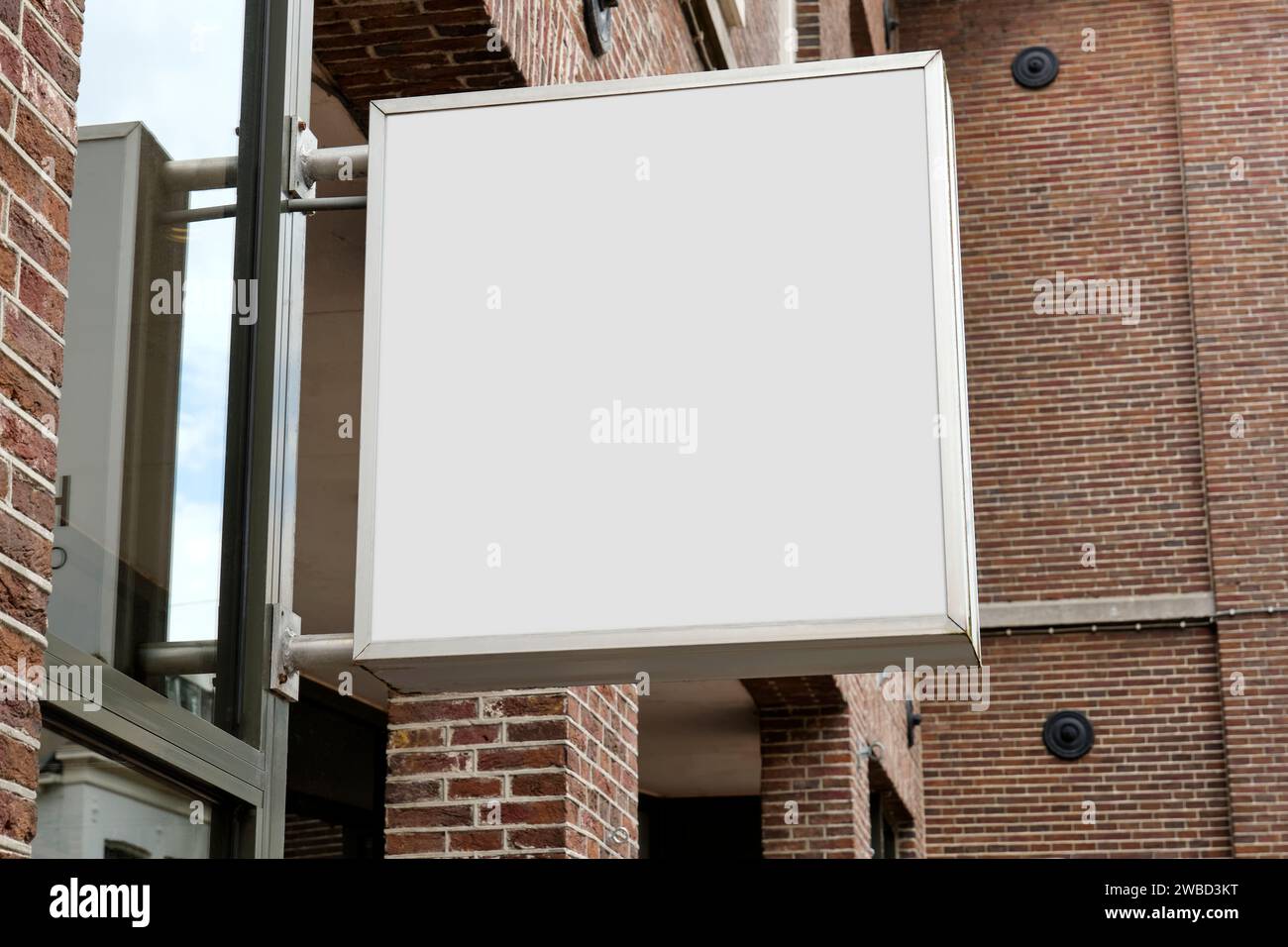 Boîte à lumière blanche carrée accrochée sur un mur de briques dans une rue pour utiliser un modèle ou une maquette Banque D'Images