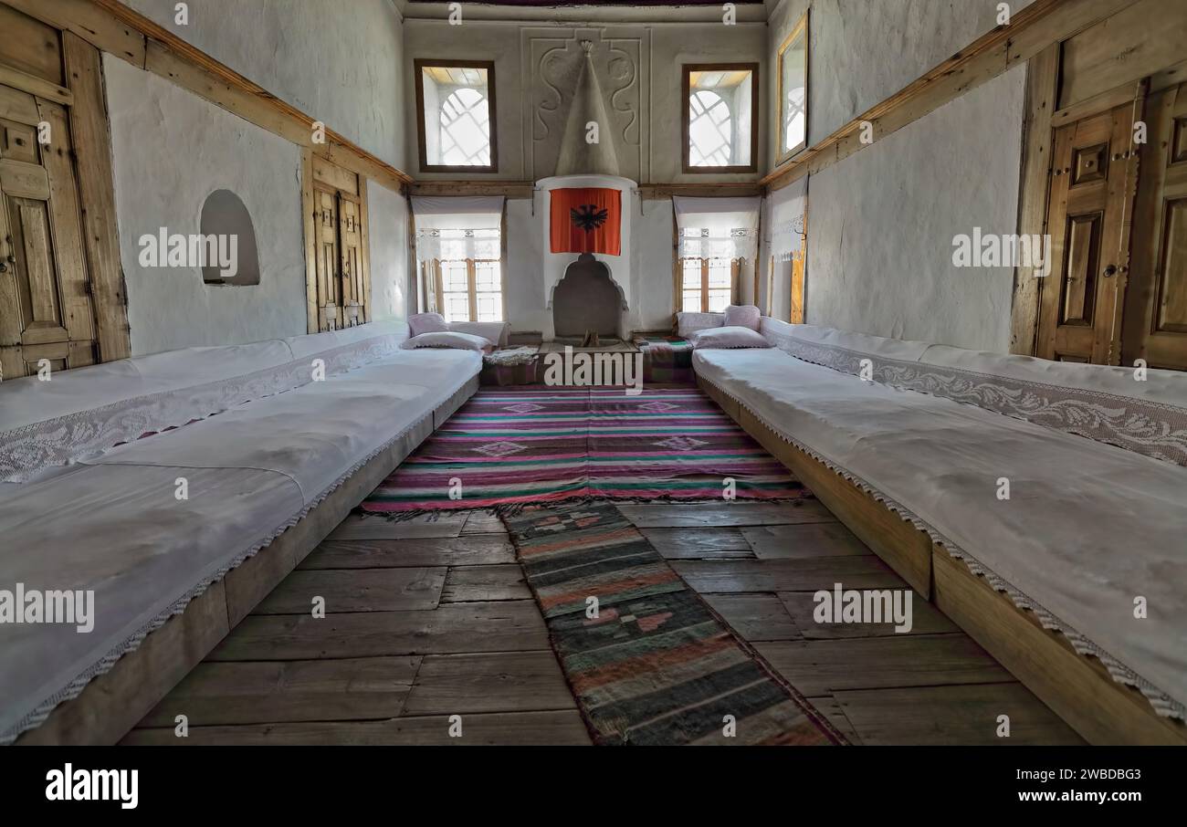 223+ début des années 1700 Maison ottomane salon avec tapis kilim tissés à la main, longs canapés latéraux, immense cheminée. Gjirokaster-Albanie. Banque D'Images