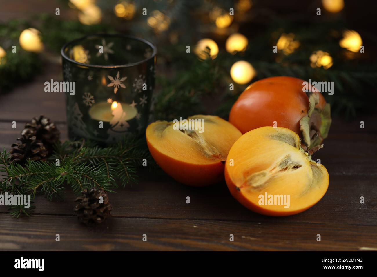 Kakis orange vif tranchés sur le fond en bois Banque D'Images