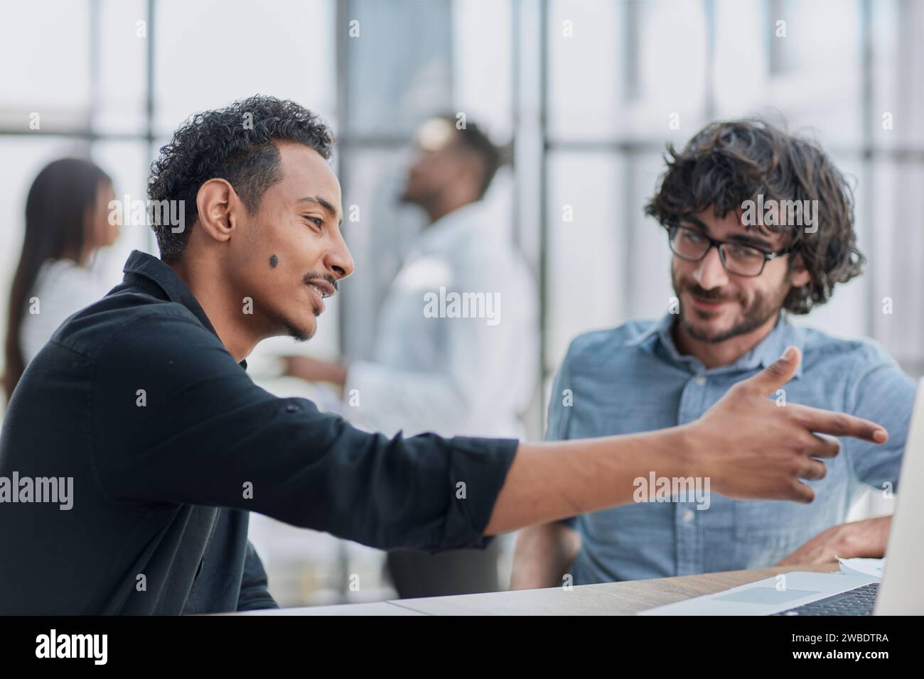 Professionnels d'affaires collaborant joyeusement dans un bureau moderne avec la technologie. Banque D'Images
