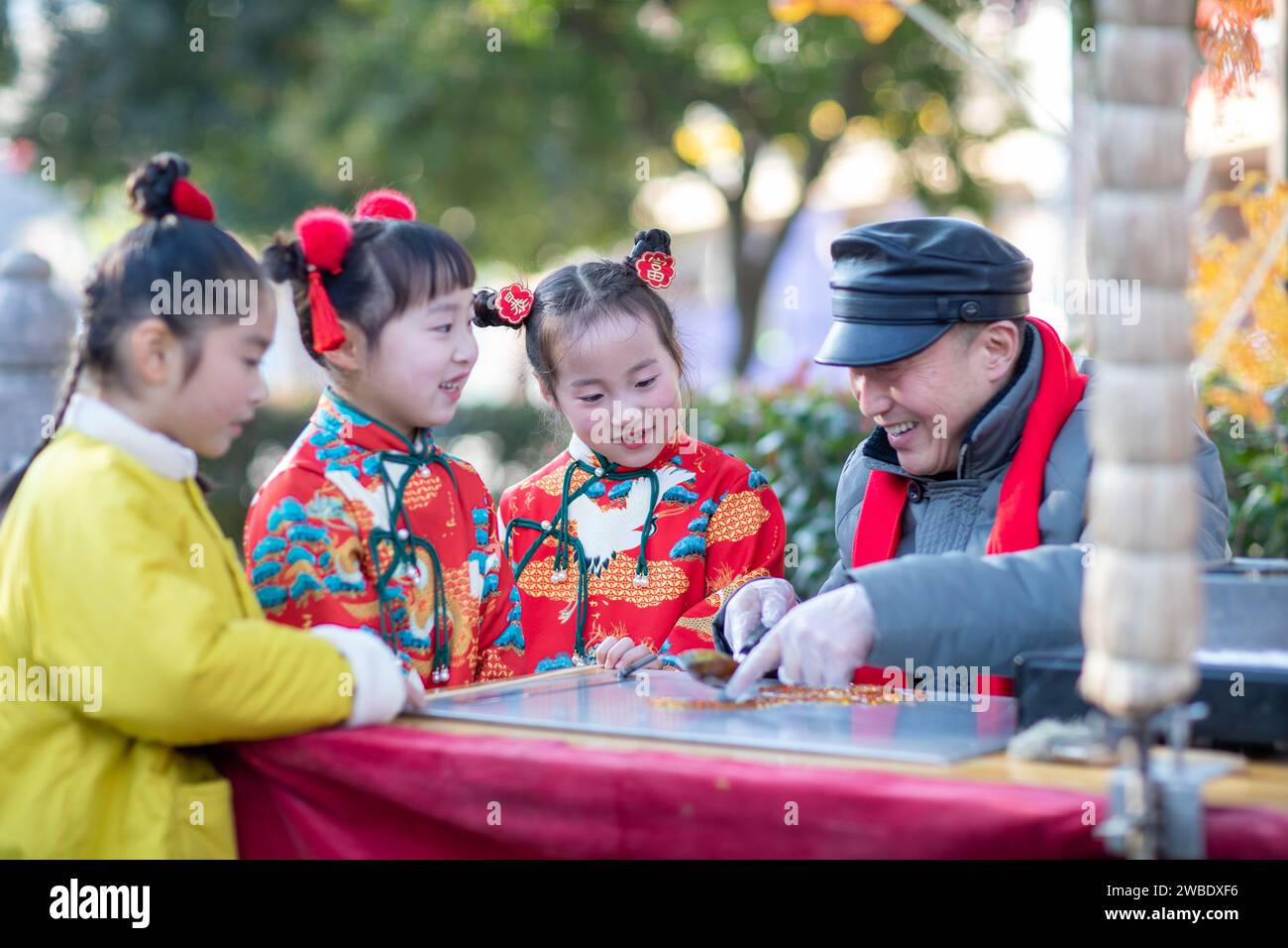 XINGHUA, CHINE - 10 JANVIER 2024 - des enfants regardent une peinture à sucre en forme de dragon faite par une personne non héritée à Xinghua, Jiangsu prov Banque D'Images