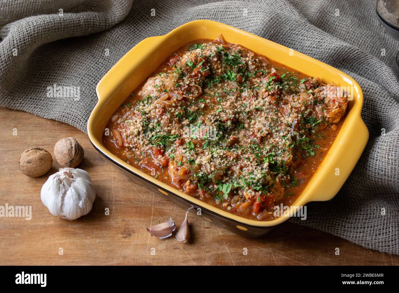 Chakhbili avec poulet et légumes cuisine géorgienne vue de dessus sur la vieille table en bois. Noix et ail Banque D'Images