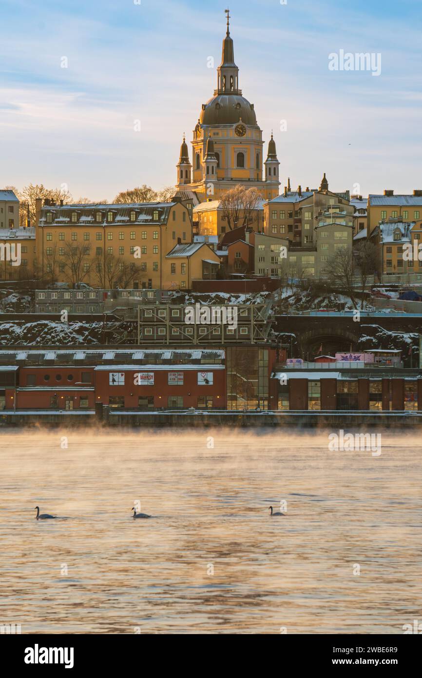 Église Saint Katarina à Stockholm, Suède par un matin amèrement froid, mer fumante, cygnes nageant par. Côté nord de l'île de Södermalm. Banque D'Images