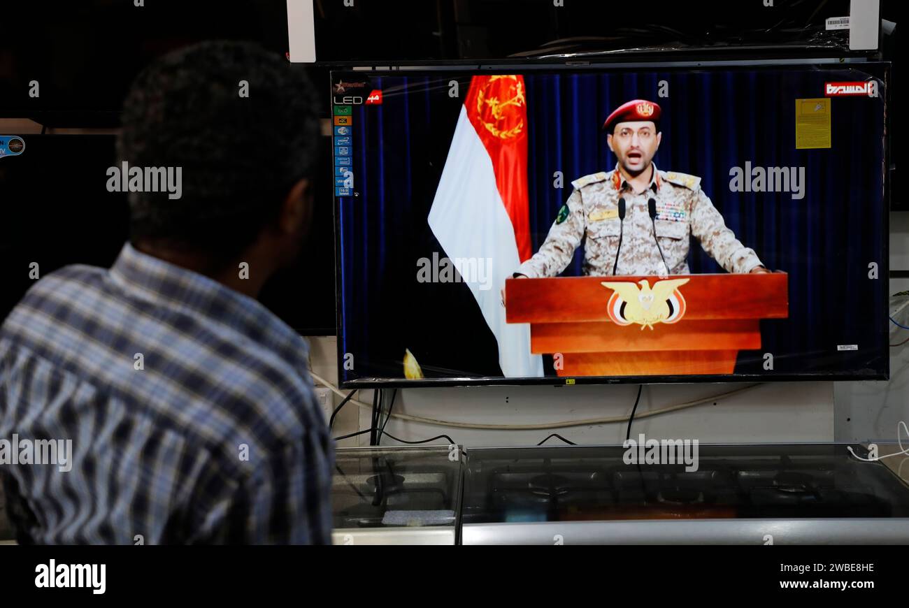 Sanaa, Sanaa, Yémen. 10 janvier 2024. Des hommes regardent une déclaration télévisée du porte-parole des Houthis Yahya Saree après que les Houthis ont attaqué le navire dans la mer Rouge. Le groupe Houthi du Yémen a déclaré mercredi qu'ils avaient lancé ''un nombre significatif'' de drones et de missiles vers un navire de la marine américaine dans la mer Rouge, qui soutenaient Israël. le porte-parole militaire du groupe, Yahya Sarea, a déclaré que les combattants avaient lancé de nombreux ''missiles balistiques et navals'' et drones sur le navire américain, qualifiant l'attaque de ''représailles préliminaires'' pour le naufrage américain de Ho Banque D'Images