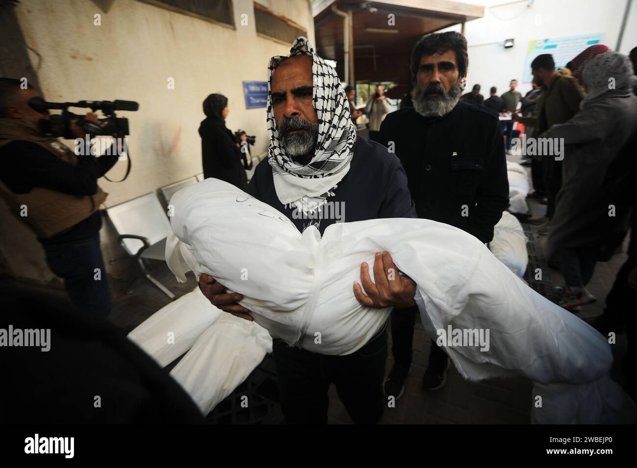Rafah, Gaza. 09 janvier 2024. Un palestinien porte le corps d’un enfant tué dans un bombardement israélien sur une maison à Rafah, dans le Sud de la bande de Gaza, le mercredi 10 janvier 2024. Plus de 20 000 Palestiniens sont morts pendant le conflit israélo-Gaza. Le secrétaire d'État américain Antony Blinken est au Moyen-Orient pour se prémunir contre l'élargissement de la guerre. Photo par Ismael Mohamad/UPI crédit : UPI/Alamy Live News Banque D'Images