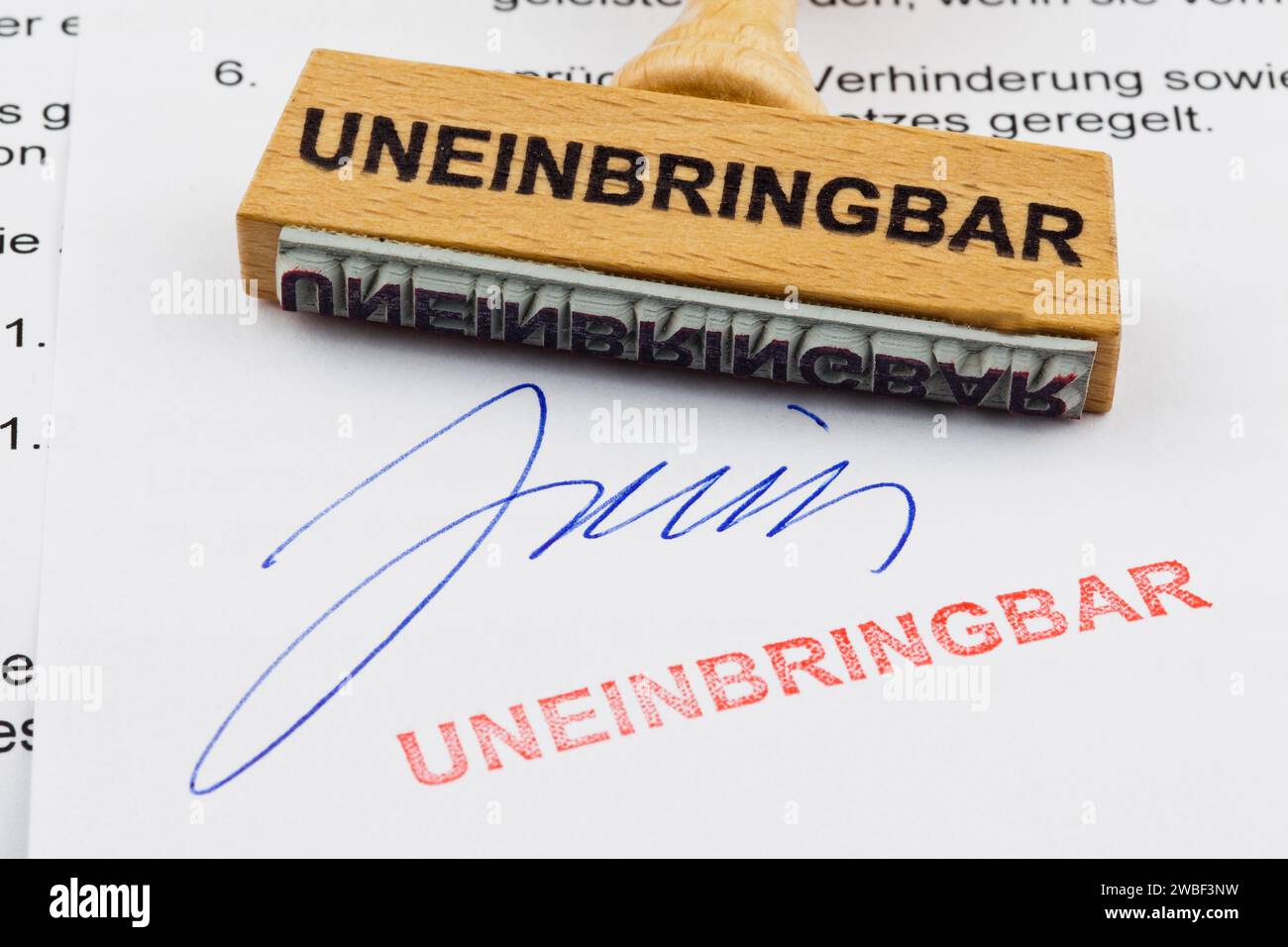 Un tampon en bois se trouve sur un document. Inscription allemande : irrécupérable Banque D'Images